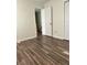 Bedroom boasting dark laminate flooring, neutral walls, and trim with ample closet space in a well-lit area at 5458 Stagecoach Rd, Ellenwood, GA 30294