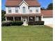 Charming two-story home featuring a welcoming front porch, manicured landscaping, and an attached two-car garage at 5458 Stagecoach Rd, Ellenwood, GA 30294