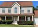 Charming two-story home featuring a brick facade and covered front porch with a manicured lawn and mature shrubs at 5458 Stagecoach Rd, Ellenwood, GA 30294