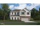 Charming two-story home features a brick and vinyl exterior, attached garage, and landscaped yard at 616 Blue Sky Blvd, Acworth, GA 30102