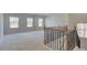 Spacious bonus room featuring plush carpeting, ample natural light, and decorative wrought iron staircase detail at 76 Homesite Dulles Dr, Mcdonough, GA 30253