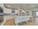 Bright kitchen featuring stainless appliances, white cabinets, island with sink, and wood-look flooring at 76 Homesite Dulles Dr, Mcdonough, GA 30253