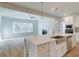 Modern kitchen featuring stainless appliances, white cabinets, island with sink, and an adjacent living area at 76 Homesite Dulles Dr, Mcdonough, GA 30253