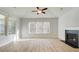 Bright living room featuring a fireplace, windows with a view, a ceiling fan, and wood-look flooring at 76 Homesite Dulles Dr, Mcdonough, GA 30253