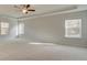 Spacious primary bedroom with tray ceiling, carpet, and multiple windows at 76 Homesite Dulles Dr, Mcdonough, GA 30253