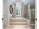 Bright bathroom featuring tile floors, a large tub, and a glass shower at 1100 Lady Slipper Way, Canton, GA 30115