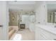 Bathroom featuring white cabinetry, double sinks, tile floors, a glass shower, and a soaking tub at 1100 Lady Slipper Way, Canton, GA 30115