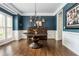 Formal dining room featuring dark blue walls, hardwood floors, and elegant chandelier lighting at 1100 Lady Slipper Way, Canton, GA 30115