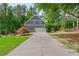 Charming home with a spacious driveway and a two-car garage nestled among mature trees at 1100 Lady Slipper Way, Canton, GA 30115