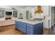 Bright kitchen features a large island, stainless appliances, custom cabinets, and a view to the living room at 1100 Lady Slipper Way, Canton, GA 30115