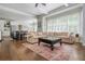 Open-concept living room with a large sectional couch, hardwood floors, and a view of the kitchen at 1100 Lady Slipper Way, Canton, GA 30115