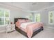 Bright bedroom featuring a tray ceiling with a chandelier and large windows with shutter-style blinds at 1100 Lady Slipper Way, Canton, GA 30115