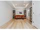 Bright office features hardwood floors, built in bookshelves, an orange sofa, and recessed lighting at 1100 Lady Slipper Way, Canton, GA 30115