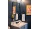 Charming bathroom with a vintage mirror, floral artwork, and modern fixtures, blending classic and contemporary styles at 1320 Country Acres Ln, Lawrenceville, GA 30045