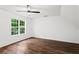 Bright bedroom featuring hardwood floors, a ceiling fan, and a window providing natural light at 1320 Country Acres Ln, Lawrenceville, GA 30045