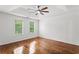 Spacious bedroom featuring hardwood floors, tray ceiling, ceiling fan and bright windows at 1320 Country Acres Ln, Lawrenceville, GA 30045