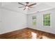 Bright bedroom with hardwood floors, a ceiling fan and two bright windows with trees outside at 1320 Country Acres Ln, Lawrenceville, GA 30045
