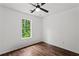 Bedroom featuring hardwood floors, a ceiling fan, and a window overlooking the property at 1320 Country Acres Ln, Lawrenceville, GA 30045