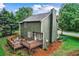 Rear exterior view of a green two-story house with a wooden deck and well-manicured landscaping at 1320 Country Acres Ln, Lawrenceville, GA 30045