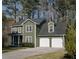 Traditional two-story home with attached two-car garage, manicured lawn and mature trees at 1320 Country Acres Ln, Lawrenceville, GA 30045