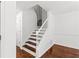 Hardwood staircase in a home's entryway with white walls at 1320 Country Acres Ln, Lawrenceville, GA 30045