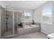 Modern bathroom featuring a glass-enclosed shower, soaking tub, and large window for natural light at 2100 Drew Nw Dr, Atlanta, GA 30318
