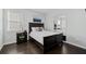 Cozy bedroom featuring dark wood floors, a bed with white bedding, and a large mirror at 2100 Drew Nw Dr, Atlanta, GA 30318
