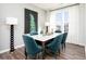 Bright dining room showcases a marble-top table, luxurious blue chairs, statement lighting, and large windows with elegant curtains at 339 Skylar Se Way, Atlanta, GA 30315