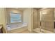 Bright bathroom with a soaking tub and glass-enclosed shower at 5010 Lynnonhall Ct, Stonecrest, GA 30038