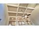 Dramatic view showcasing the coffered ceiling and ceiling fan in this light-filled living space at 5010 Lynnonhall Ct, Stonecrest, GA 30038