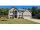 Charming two-story brick home featuring a well-manicured lawn and an attached two-car garage at 5010 Lynnonhall Ct, Stonecrest, GA 30038