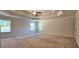 Large main bedroom featuring a tray ceiling, fan, and ample natural light at 5010 Lynnonhall Ct, Stonecrest, GA 30038