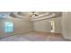An airy main bedroom with neutral walls, carpet flooring, and tray ceiling at 5010 Lynnonhall Ct, Stonecrest, GA 30038