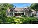 Expansive backyard with a manicured lawn, mature trees, and a traditional-style home with large windows at 5360 Lake Forrest Dr, Atlanta, GA 30342
