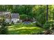 Private backyard with a pool, outdoor fireplace, lush greenery, and a charming fence at 5360 Lake Forrest Dr, Atlanta, GA 30342