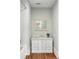 Bathroom featuring a white vanity with marble countertop, framed mirror, white subway tile and wood look flooring at 5360 Lake Forrest Dr, Atlanta, GA 30342