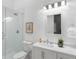 Modern bathroom featuring a frameless glass shower, white cabinets, and decorative light fixtures at 5360 Lake Forrest Dr, Atlanta, GA 30342