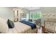 Bright bedroom featuring a crib, area rug, and natural light streaming through the large window at 5360 Lake Forrest Dr, Atlanta, GA 30342