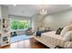 Charming bedroom with hardwood floors, chandelier lighting, and natural light from the large window overlooking the yard at 5360 Lake Forrest Dr, Atlanta, GA 30342