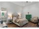Bright bedroom showcases wood floors, a green dresser, and an adjacent bathroom with double vanity at 5360 Lake Forrest Dr, Atlanta, GA 30342
