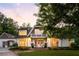 Charming two-story home with a brick walkway, white facade, and balcony against a colorful sunset at 5360 Lake Forrest Dr, Atlanta, GA 30342