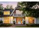 Elegant exterior view of a home with a balcony, warm lighting, and manicured landscaping at 5360 Lake Forrest Dr, Atlanta, GA 30342