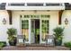 Inviting front entrance with white brick, wooden beams, brick steps, and stylish rocking chairs at 5360 Lake Forrest Dr, Atlanta, GA 30342