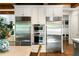 Kitchen showcasing stainless steel appliances, custom cabinetry, and a dining area with woven chairs at 5360 Lake Forrest Dr, Atlanta, GA 30342