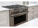 Close-up of a modern stainless steel oven with a stovetop and white cabinets at 5360 Lake Forrest Dr, Atlanta, GA 30342