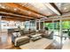 Open concept living room with wood ceiling, fireplace, hardwood floors and view to a backyard patio at 5360 Lake Forrest Dr, Atlanta, GA 30342