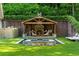 Outdoor fireplace features seating, a water feature, and manicured landscaping at 5360 Lake Forrest Dr, Atlanta, GA 30342