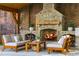 Outdoor stone fireplace with seating area, wood storage and brick backdrop at 5360 Lake Forrest Dr, Atlanta, GA 30342