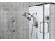 Close-up of the dog showerhead, tiled walls, and glass shower doors at 5360 Lake Forrest Dr, Atlanta, GA 30342