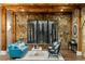 Stylish wine cellar featuring stone accents, a blue sofa, and a custom wine rack display at 5360 Lake Forrest Dr, Atlanta, GA 30342